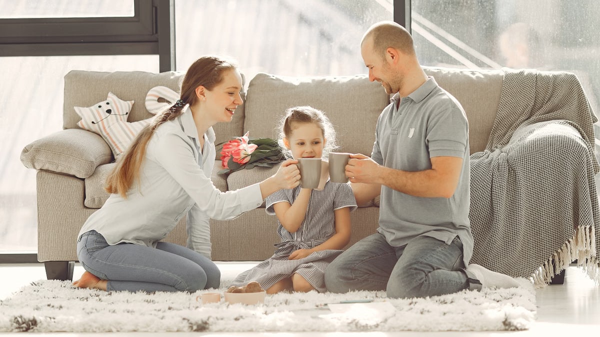 A joyful family enjoying quality time and coffee in a bright living room, symbolizing love and togetherness.