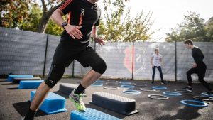 man in black crew neck t-shirt and black shorts running on blue and white trampoline