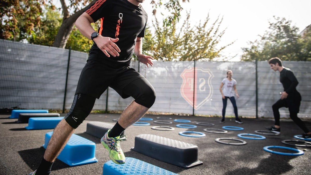 man in black crew neck t-shirt and black shorts running on blue and white trampoline