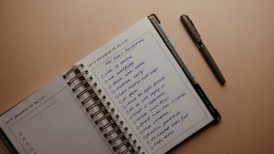 An open notebook on a brown background featuring handwritten New Year's resolutions.